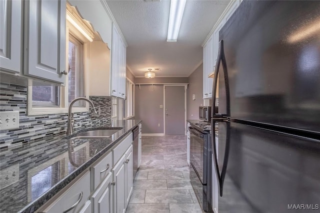 kitchen with dark stone counters, black appliances, crown molding, sink, and white cabinetry