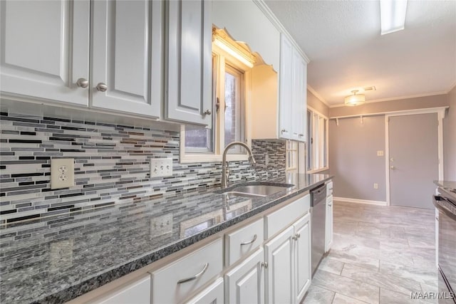 kitchen with stainless steel appliances, crown molding, sink, dark stone countertops, and white cabinets