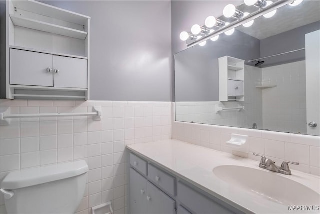 bathroom featuring vanity, tile walls, and toilet