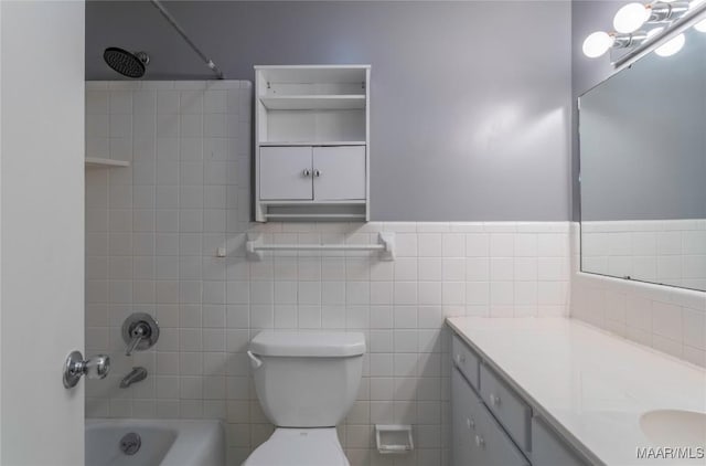 full bathroom with shower / bathing tub combination, vanity, toilet, and tile walls