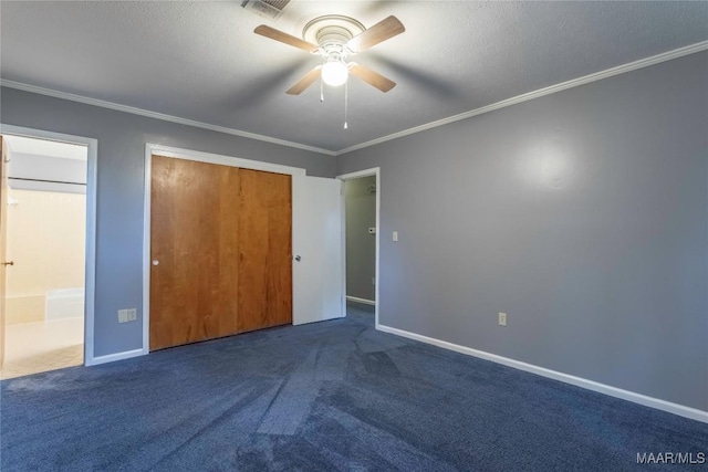 unfurnished bedroom featuring dark colored carpet, ceiling fan, ornamental molding, and a closet