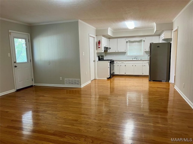 kitchen with white cabinets, light wood-type flooring, stainless steel appliances, and crown molding