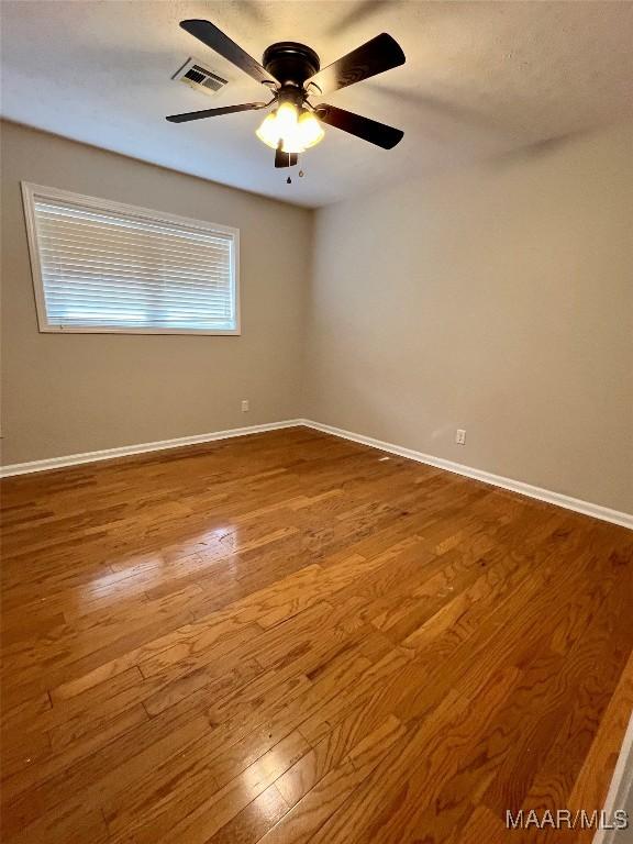 unfurnished room featuring hardwood / wood-style floors and ceiling fan