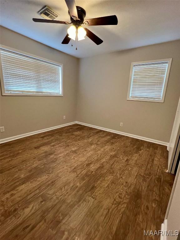 spare room featuring ceiling fan and dark wood-type flooring