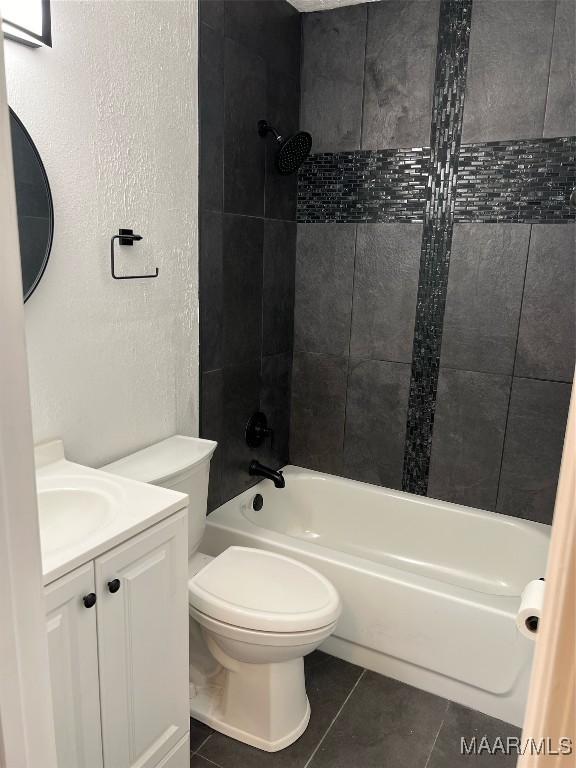 full bathroom with tile patterned floors, tiled shower / bath combo, toilet, and vanity