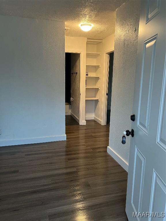 unfurnished room featuring dark hardwood / wood-style floors and a textured ceiling