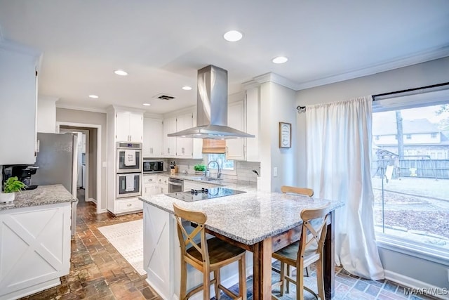 kitchen featuring decorative backsplash, kitchen peninsula, wall chimney exhaust hood, sink, and white cabinets