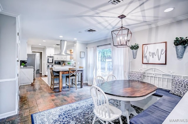 dining area featuring sink, a chandelier, and ornamental molding