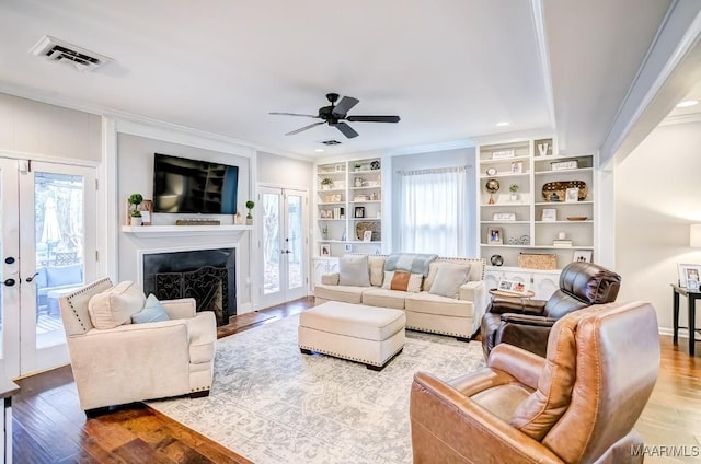 living room featuring a healthy amount of sunlight, light hardwood / wood-style floors, and ornamental molding