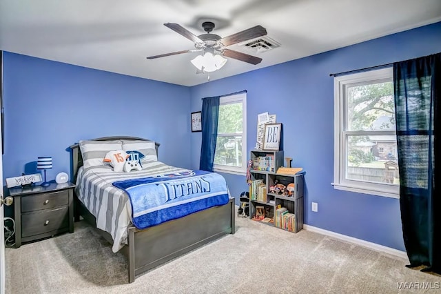 carpeted bedroom featuring ceiling fan and multiple windows