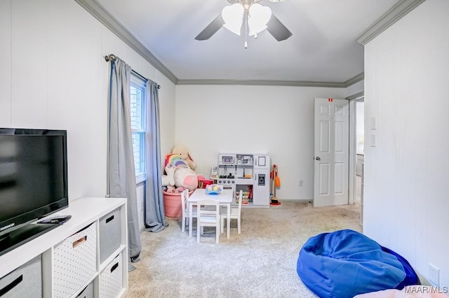 recreation room with light carpet, ceiling fan, and ornamental molding