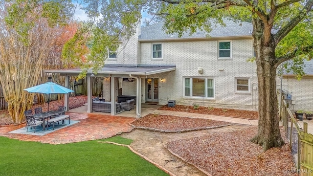 back of property featuring an outdoor living space, a patio area, and a yard