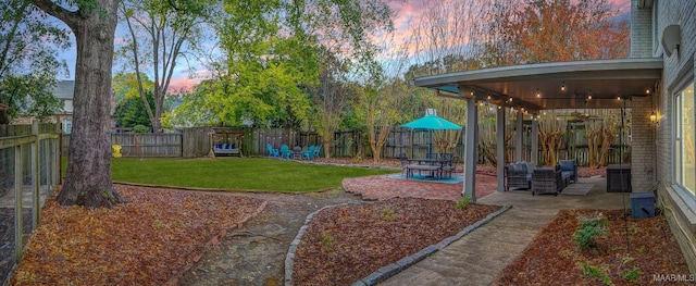 yard at dusk with a patio area