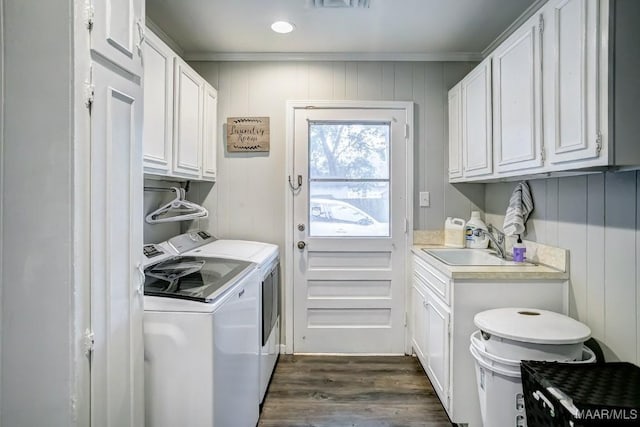 washroom with cabinets, crown molding, dark wood-type flooring, sink, and washing machine and dryer