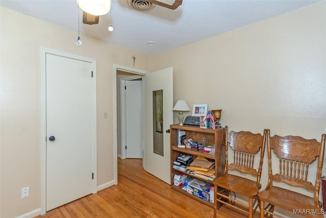 living area featuring light hardwood / wood-style floors and ceiling fan