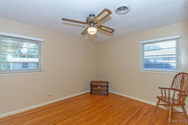 spare room featuring ceiling fan, a healthy amount of sunlight, and light hardwood / wood-style floors