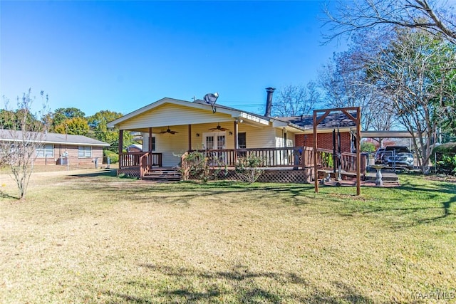 back of property featuring a lawn and ceiling fan