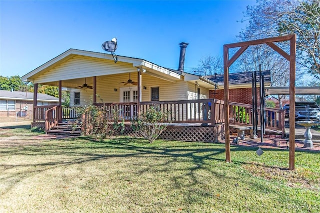 rear view of house with a yard, ceiling fan, and a wooden deck