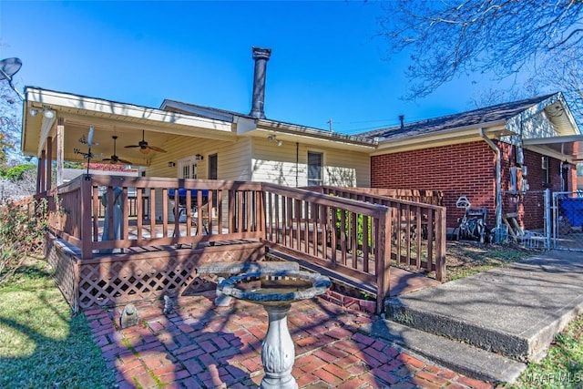 back of property with a wooden deck, ceiling fan, and a patio area