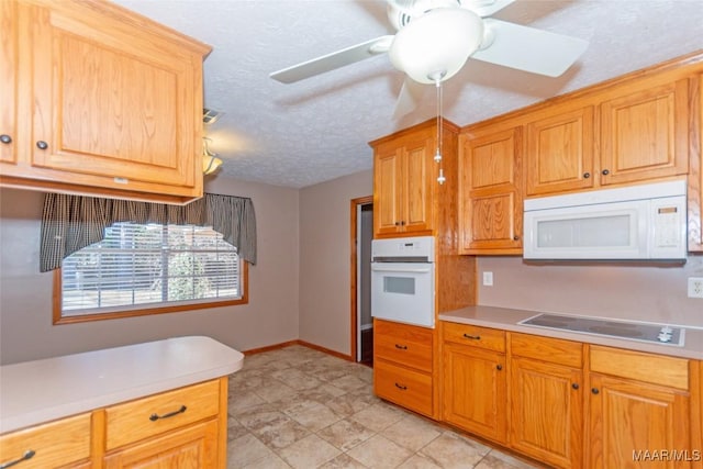 kitchen featuring a textured ceiling, ceiling fan, and white appliances