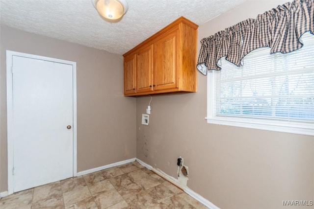 laundry area featuring cabinets, washer hookup, and a textured ceiling