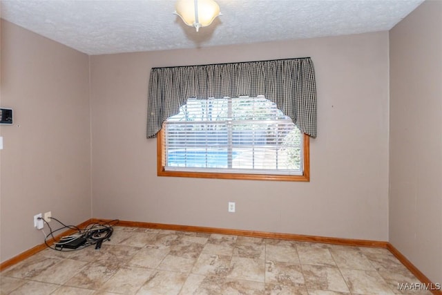 unfurnished room with a textured ceiling