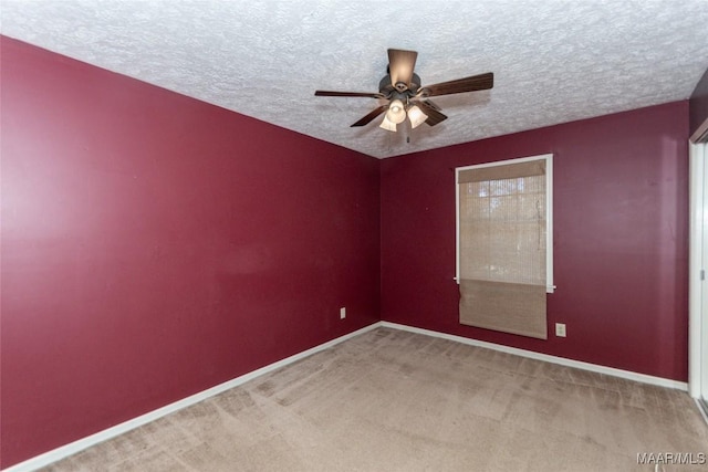 carpeted spare room with ceiling fan and a textured ceiling