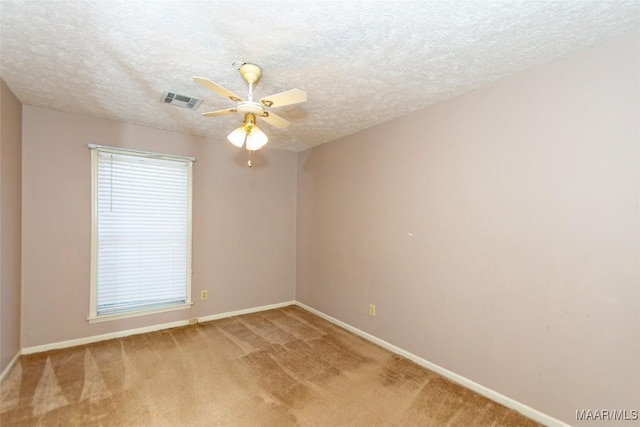 carpeted empty room featuring ceiling fan and a textured ceiling