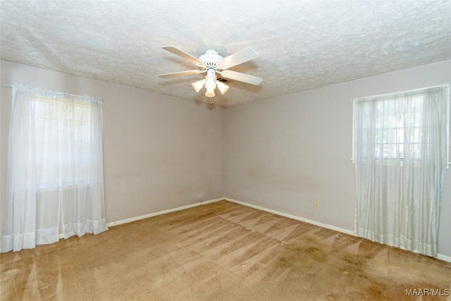 unfurnished room featuring ceiling fan, a healthy amount of sunlight, and light colored carpet