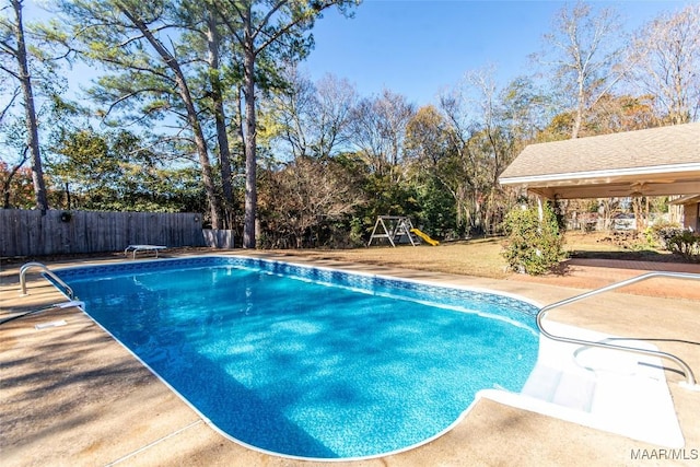 view of pool featuring a playground, a patio area, and a diving board