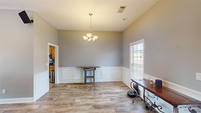 dining room with light hardwood / wood-style floors and an inviting chandelier