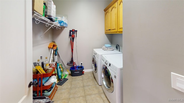 laundry room with cabinets, light tile patterned floors, and separate washer and dryer