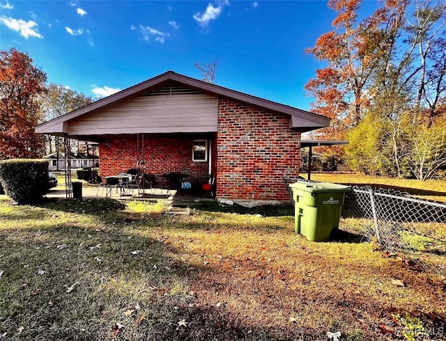 view of side of property with a lawn and a patio area