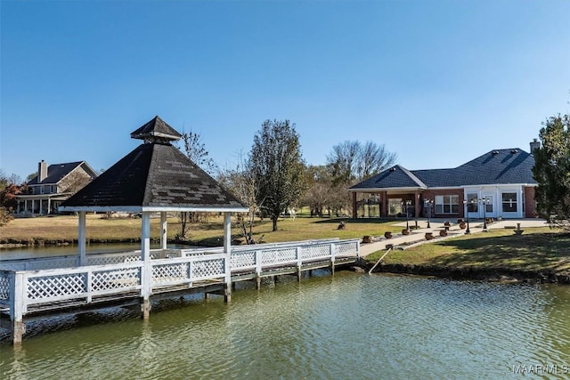 view of dock featuring a gazebo, a yard, and a water view