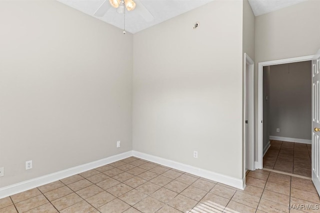 spare room with ceiling fan and light tile patterned flooring