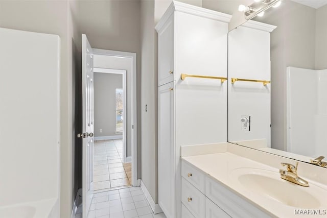 bathroom with tile patterned flooring, vanity, and a bath