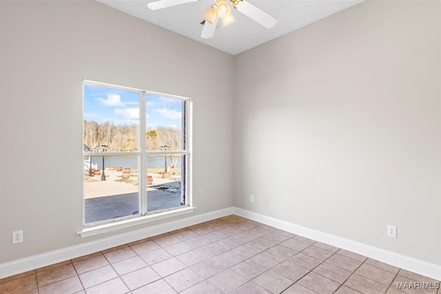 empty room featuring light tile patterned floors, a water view, and ceiling fan