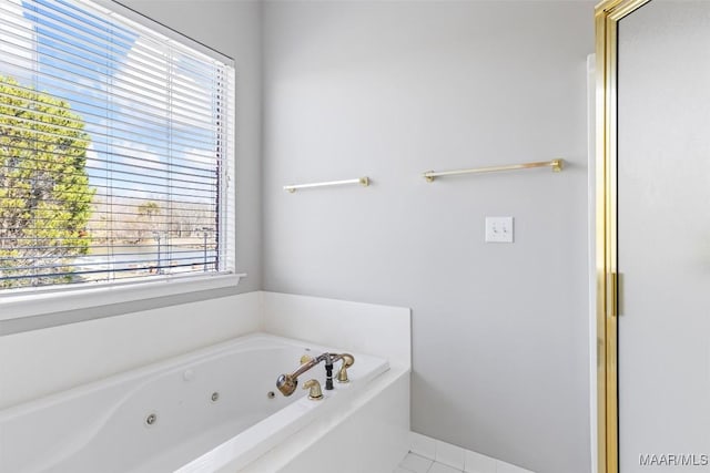 bathroom with tile patterned flooring, a bathtub, and a healthy amount of sunlight