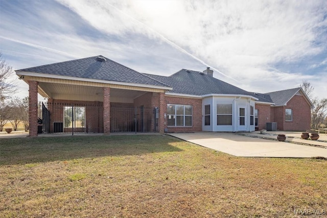 rear view of property with cooling unit, a yard, and a patio