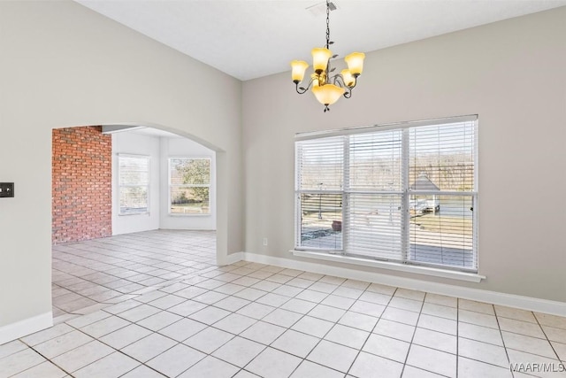 unfurnished room featuring a chandelier and light tile patterned floors