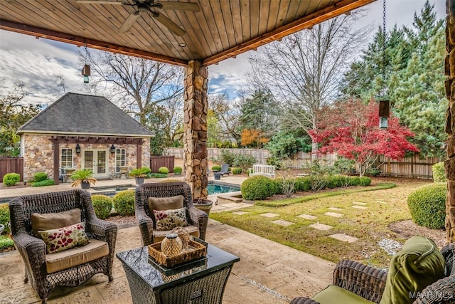 view of patio with ceiling fan, a fenced in pool, and an outbuilding