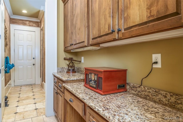 kitchen featuring light stone counters and ornamental molding