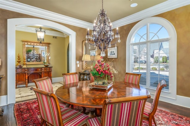 dining room with hardwood / wood-style floors, a notable chandelier, and ornamental molding