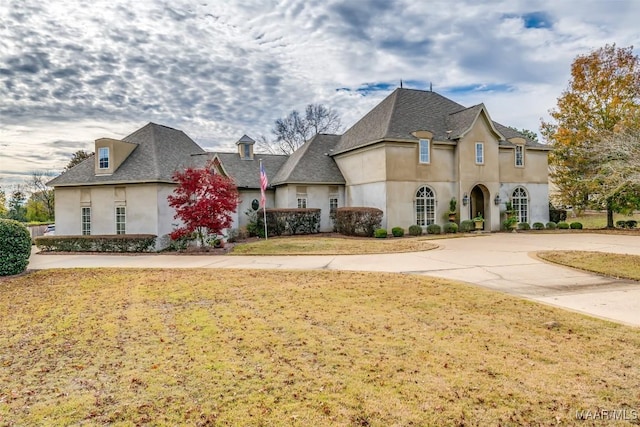 french country style house with a front lawn