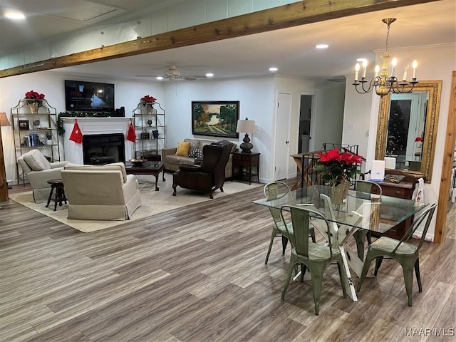 dining room featuring hardwood / wood-style floors, ceiling fan with notable chandelier, beam ceiling, and ornamental molding