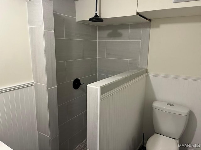 bathroom featuring tiled shower and toilet