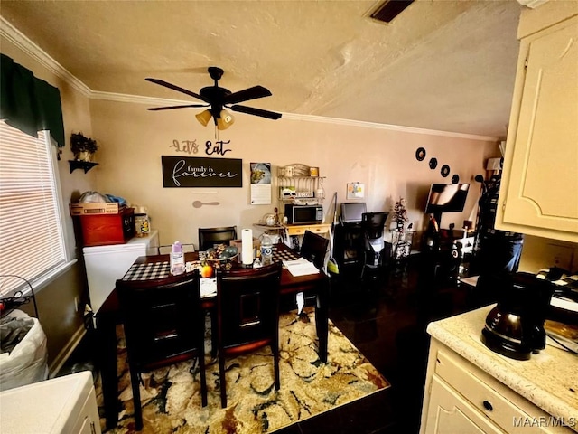 dining space with ceiling fan and crown molding