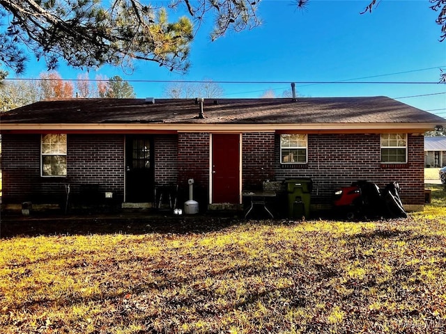 rear view of property featuring a lawn