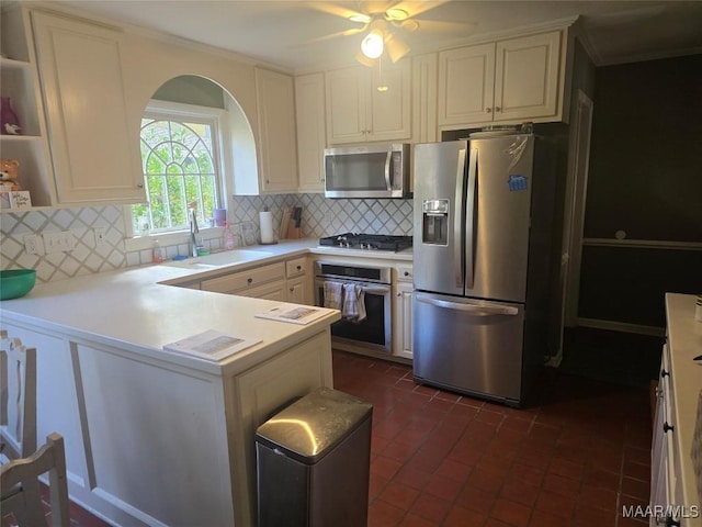 kitchen featuring ceiling fan, sink, backsplash, kitchen peninsula, and appliances with stainless steel finishes