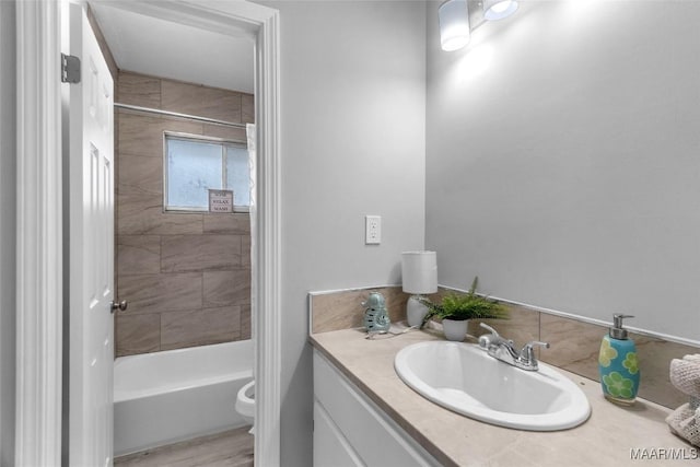 full bathroom featuring vanity, toilet, wood-type flooring, and tiled shower / bath combo